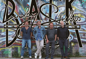 Bandfoto Lucky Strikes Back: Vier Männer vor Graffiti-Wand

Vier Personen stehen nebeneinander vor einer bunten Graffiti-Wand mit großem Schriftzug. Sie tragen Freizeitkleidung in dunklen Tönen. Der Hintergrund ist urban und farbig gestaltet.