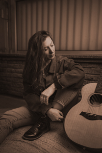 Bandfoto Nica: Musikerin mit Gitarre im Innenraum (Sepia-Ton)

Eine Person sitzt auf dem Boden in einem Innenraum und lehnt an einer Wand. Neben ihr liegt eine Akustikgitarre. Das Bild ist in warmem Sepia-Ton gehalten und zeigt eine ruhige, intime Szene.